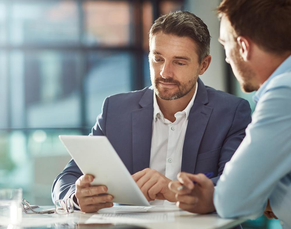 Profissionais em uma reunião conversando sobre um documento